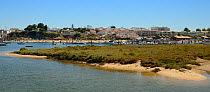 Saltmarsh and estuarine harbour at high tide with moored sailing yachts, Alvor, near Portimao, Algarve, Portugal, July 2013.