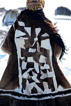Nenet teenager dressed in traditional winter coat made with reindeer skin.  Yar-Sale district, Yamal, Northwest Siberia, Russia. April 2016.