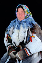 Ekaterina Yaptik, portrait of Nenet herder in winter coat of reindeer fur. The collar is arctic fox fur with black beaver fur and felt ribbons. Yar-Sale district, Yamal, Northwest Siberia, Russia. Apr...