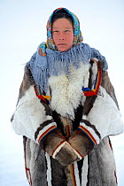Ekaterina Yaptik, portrait of Nenet herder in winter coat of reindeer fur. The collar is arctic fox fur with black beaver fur and felt ribbons. Yar-Sale district, Yamal, Northwest Siberia, Russia. Apr...