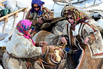 Nenet women spinning reindeer sinew to sew reindeer skin. Yar-Sale district. Yamal, Northwest Siberia, Russia. April 2016.