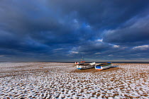 Cley Beach with scattering of light snow, and boats,  Norfolk, England, UK, December 2010.