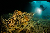 Diver investigates a second world war motorbike with his torch in the cargo hold of the SS Thistlegorm, northern Red Sea, February.