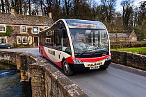 Rural public transport, a Cotswold Discoverer Bus on bridge in Northleach, Gloucestershire, UK. March 2014.