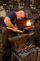 Rural blacksmith at work, Cherington Forge, Cherington, Gloucestershire, UK. September 2015.