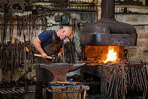 Rural blacksmith at work, Cherington Forge, Cherington, Gloucestershire, UK. September 2015.