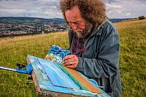 Landscape painter Ian Shearman  painting landscape on Selsley Common, Stroud, Gloucestershire, UK. September 2015.