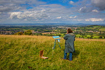 Landscape painter Ian Shearman  painting landscape on Selsley Common, Stroud, Gloucestershire, UK. September 2015.