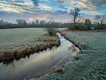 River Eye flowing through water meadows on Greystones Farm Nature Reserve, Site of Special Scientific Interest (SSSI). Gloucestershire Wildlife Trust, Bourton-on-the-Water, Gloucestershire, UK. Shot b...