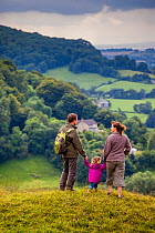 Family walking on Selsley Common on the Cotswold Way, Gloucestershire, UK. August 2012.