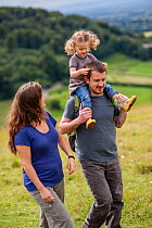 Family walking on Selsley Common on the Cotswold Way, Gloucestershire, UK. August 2012. Model released.