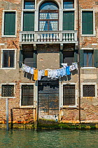 Washing drying outside Venetian waterside apartment, Venice, Italy, April.