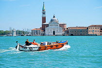 TNT delivery boat travelling to La Giudecca island, Venice, Italy.