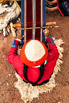 Woman sitting at backstrap loom. Planeterra-supported women's weaving project, Huchuy Qosco, indigenous village, Sacred Valley, Peru. December 2013.