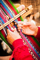Hands on loom in Planeterra-supported women's weaving project, Huchuy Qosco, indigenous village, Sacred Valley, Peru. December 2013.