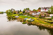 Canoes pulled up on riverbank at public house in Ross on Wye, Herefordshire, England. April 2015.