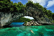 Snorkeler in front of the Arch among the rocky islands, Koror, Palau, Philippine Sea