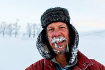 Man with ice in his beard on a frosty cold day, Yellowstone National Park, Wyoming, USA. February 2016. Model released.