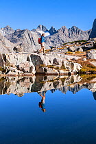 Hiker exploring mountain lake in the  Titcomb Basin, Wind River Range, Bridger Wilderness, Bridger National Forest, Wyoming, USA. September 2015. Model released.