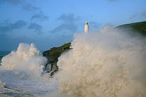 Trevose Head Lighthouse with waves crashing against cliffs, north Cornwall, England, UK, November.