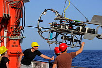 Scientists with equipment to sample deep sea marine life, Atlantic Ocean, close to Cape Verde. December 2015