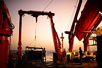 Crew lowering marine sampling equipment off ship, Atlantic Ocean, close to Cape Verde.  December 2015