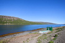Small thermal hotpool and hut on the shore of the Westfjords, Iceland, June 2011.