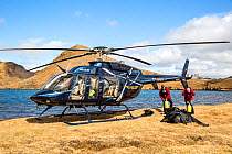 Heli-diving, downloading the scuba diving equipment from the helicopter on a mountain lake, Iceland
