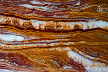 Travertine, sometimes referred to as rainbow onyx. A limestone rock deposited by mineral springs. Sample from Pakistan.