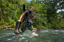 Ian Fein makes a river crossing on the way to the Oransbari Camp, West Papua.