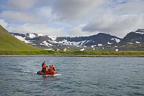 Inflatable boat picking residents up from Summer houses, Hornstrandir, Iceland. July