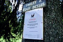 Sign warning about aggressive territorial behaviour of Western capercaillie (Tetrao urogallus) in Jura  Mountains, Switerland, June.