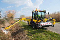 Digger clearing ditch at Notre Dame d'Amour, Camargue, France, March.