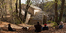 Family with dog relaxing during hike to Abbaye Notre-Dame de Lure, France, April.