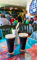 Two halves of Guinness in restaurant, Dingle Village, Dingle Peninsula, County Kerry, Republic of Ireland. September 2015.