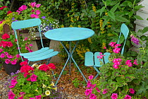 Cottage garden with container planting and blue table and chairs