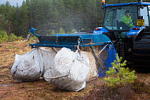 Machine collecting moss brash to distribute on bare peat as part of peatland restoration project, Inshriach, Glenfeshie, Cairngorms National Park, Scotland, UK, January 2015.
