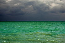 Dark rain clouds over emerald coloured sea water, Cotentin peninsula, Lower Normandy, France, October 2015.