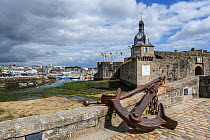 Old anchor and belfry at the entrance gate to the medieval Ville Close at Concarneau, Finistere, Brittany, France, September 2015