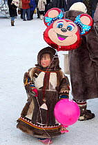 Young Nenets boy holding balloons at the reindeer herders' festival in Nadym. Yamal, Western Siberia, Russia