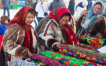 Nenets women shopping for material at a stall during the reindeer herders' festival in Nadym. Yamal, Western Siberia, Russia