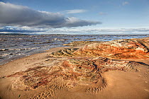 Sandstone rocks eroded by tidal action at high tide near Hilbre Point,  Hilbre Island and North Wales in the background at high tide Dee Estuary Hoylake, Wirral UK November.