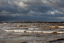 Hilbre Island viewed at high tide with gathering storm clouds from  Hilbre Point at the mouth of the Dee Estuary Wirral UK January 2016.
