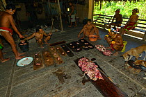 Mentawai man dividing cooked pork, Siberut Island, Sumatra. July 2016.
