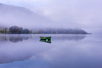 Rowing boat on Ullswater in early morning mist, Lake District, Cumbria, England, UK. November 2015.