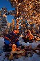 Nils-Torbjorn Nutti, owner and operator at Nutti Sami Siida, and Klara Enbom-Burreau on snowmobile trip into the wilderness, Jukkasjarvi, Lapland, Laponia, Norrbotten county, Sweden Model released.