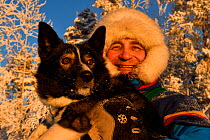 Nils-Torbjörn Nutti, owner and operator at Nutti Sami Siida, with domestic husky dog, during snowmobile trip into the wilderness, Jukkasjarvi, Lapland, Laponia, Norrbotten county, Sweden Model releas...