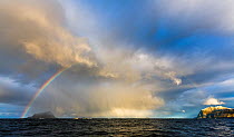 Rainbow over coastal landscape with bird cliff 'Sorfugloy' on the left, Troms, Norway, October