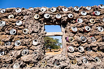 Hut wall built  with recycled  aluminium cans mixed with clay, making the walls very strong, Mababe village, Botswana