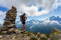 Young woman hiking in the Chamonix Valley of the French Alps, looking towards Mont Blanc mountain, France. July 2013. Model released